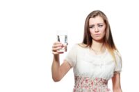 Girl looking at a glass of filtered water