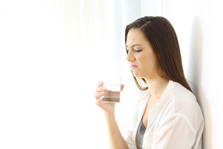 woman drinking water with bad taste isolated on white at side