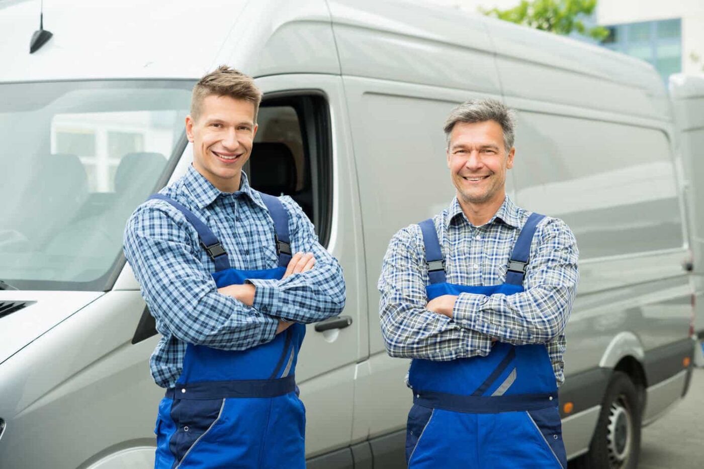 Two Repairmen With Arms Crossed In Front Of Van